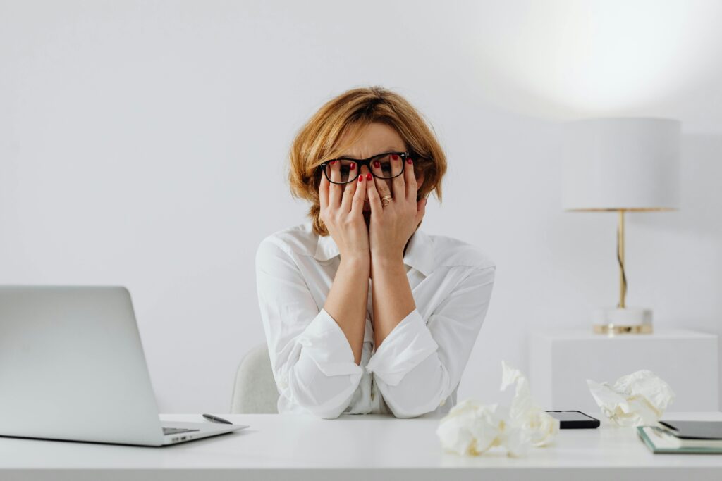 A woman over 45 wondering why Am I so tired, while holding her face with both hands