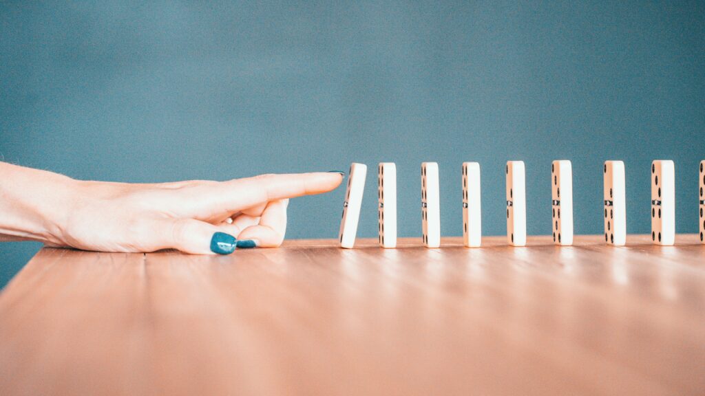 A series of falling dominoes showing the cascade effect, illustrating how blood sugar crashes trigger cortisol and wakefulness at 3 AM