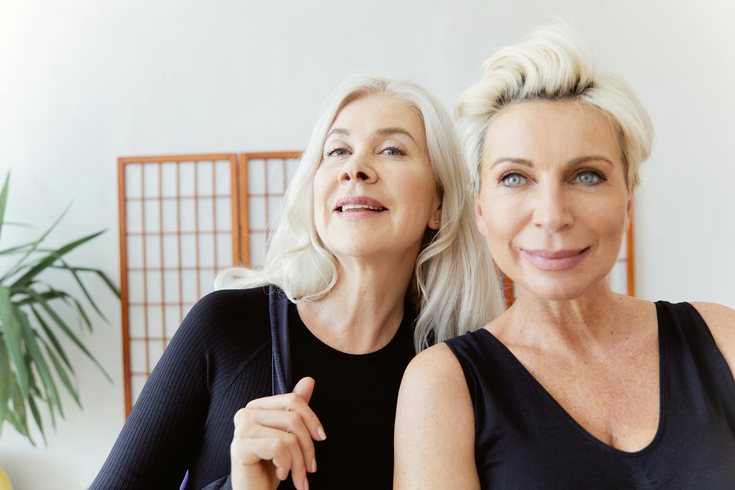 Women over 55 sitting quietly, looking tired and reflective — post-menopausal fatigue