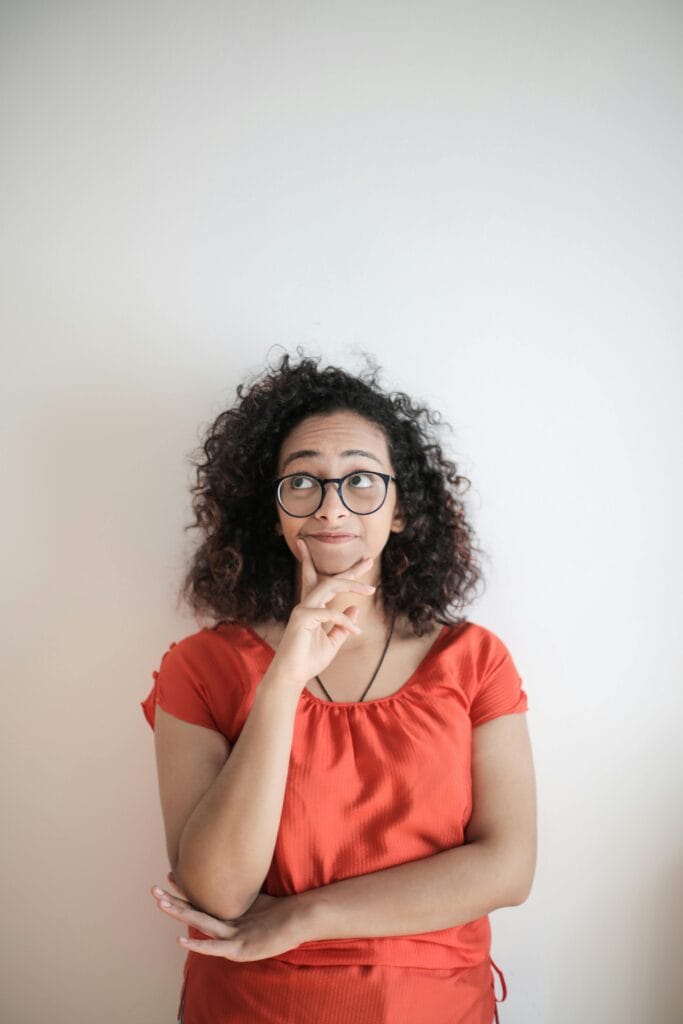 Woman over 45 thoughtfully considering two supplement bottles, deciding between moringa and turmeric for perimenopause fatigue
